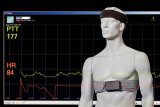 Vital parameter measurement devices (headband and chest strap) with a screenshot of the data to be monitored in the background
